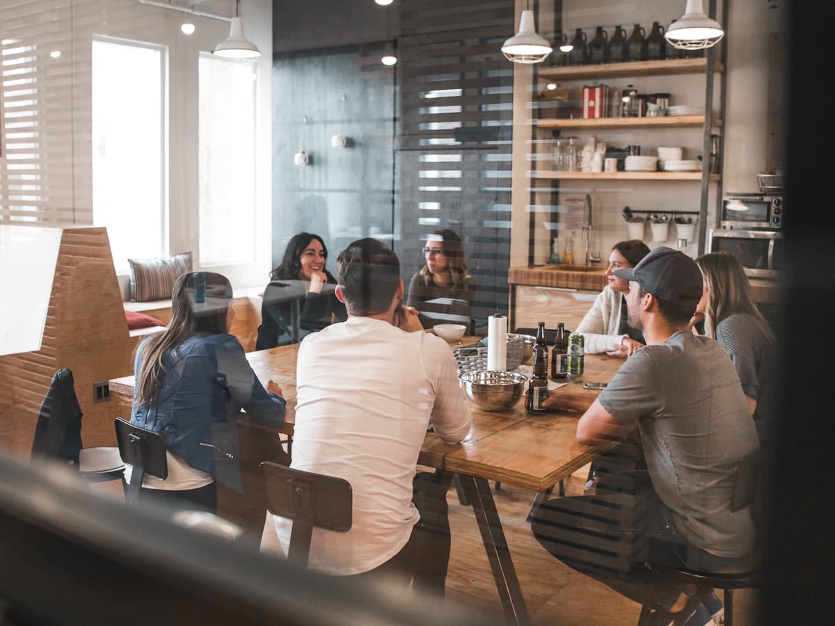 A group of students gathered around a long table talking